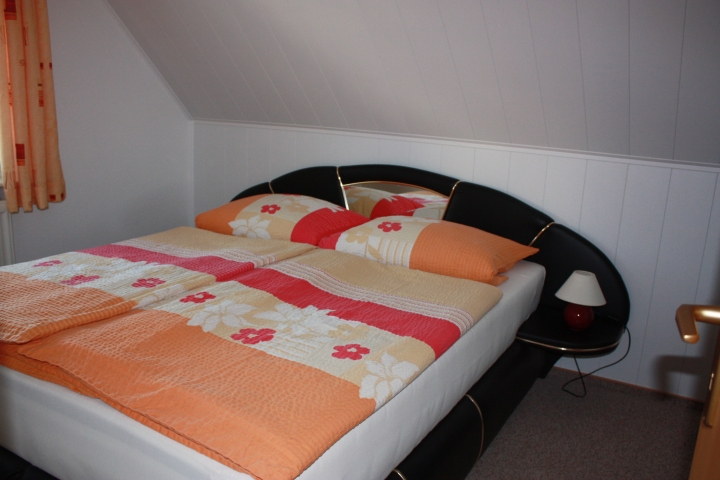 Schlafzimmer mit Doppelbett und Kleiderschrank