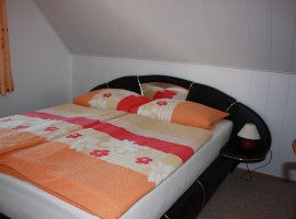 Schlafzimmer mit Doppelbett und Kleiderschrank