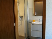 Modernes Bad mit geräumiger Dusche, zwei Schubladen im Waschtisch, zwei Haartrocknern und einem Schminkspiegel mit 2 Vergrößerungsstufen.