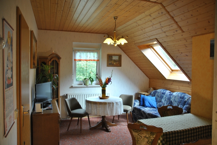 Wohnraum Fewo 5 mit Couchecke (2-fach aufklappbar) und Essecke im Dachgeschoss. Kinderstuhl vorhanden