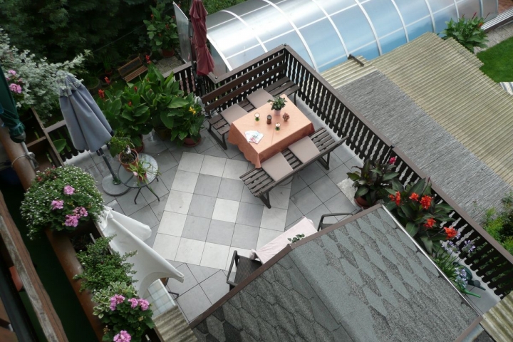 Blick auf die Terrasse vorm Gastraum sowie auf den Pool  aus der Fewo 6