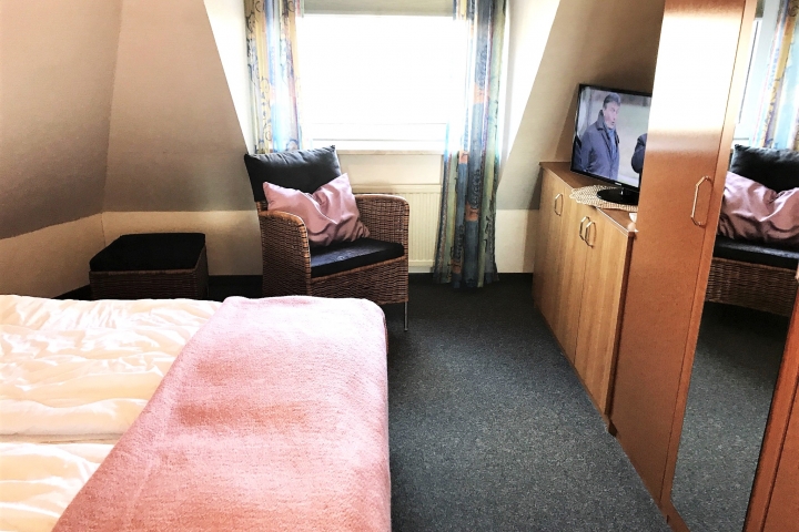 Schlafzimmer mit TV und großem Schrank