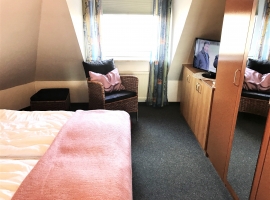 Schlafzimmer mit TV und großem Schrank