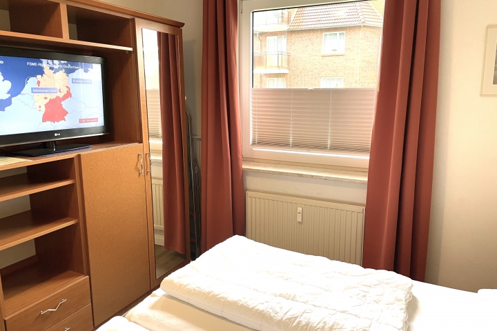 Schlafzimmer mit geräumigem Schrank und TV