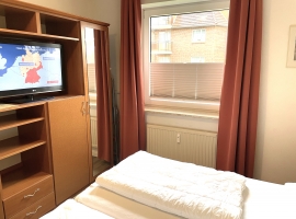 Schlafzimmer mit geräumigem Schrank und TV