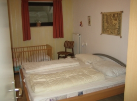 Im Schlafzimmer mit Ehebetten ist auch das Kinderbett untergebracht.