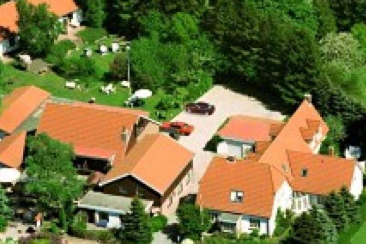 Luftaufnahme der Ferienanlage. Von links Ferienwohnungen mit Garten, im
Bereich Mitte, Hotel und Restaurant und Parkplatz.