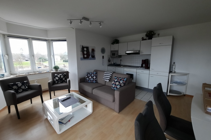 Gut eingerichtetes Wohnzimmer mit Küchenzeile.
