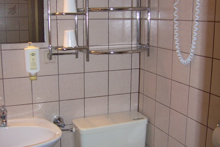 Waschbecken mit Unterschrank, Hotelfön, Kosmetiktücher, Handseife und Handtücher