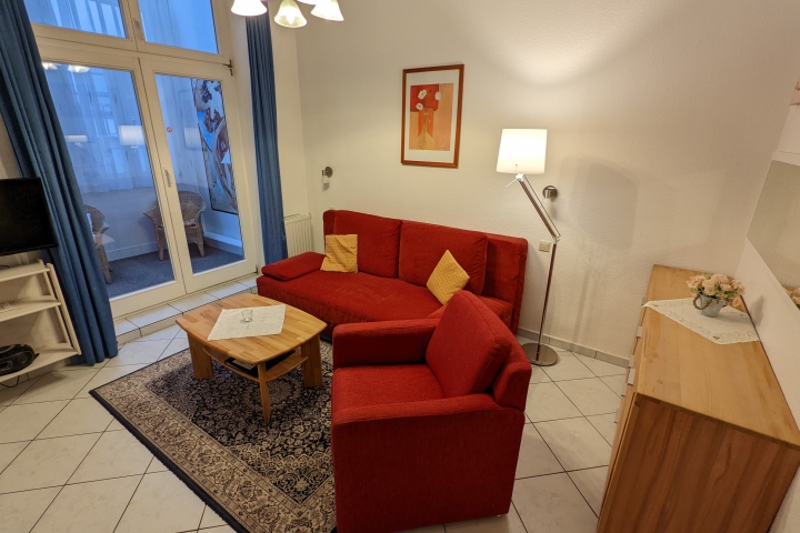 Ferienwohnungen im Haus Eintracht | Wohnzimmer mit Blick auf das Doppelbett(sofa) und Tür zur Veranda
