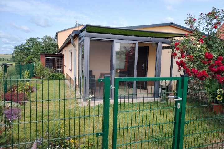 Appartement und Zimmer in Pension Schirner | Apartment mit Wintergarten und kleinem, eingezäunten Garten.