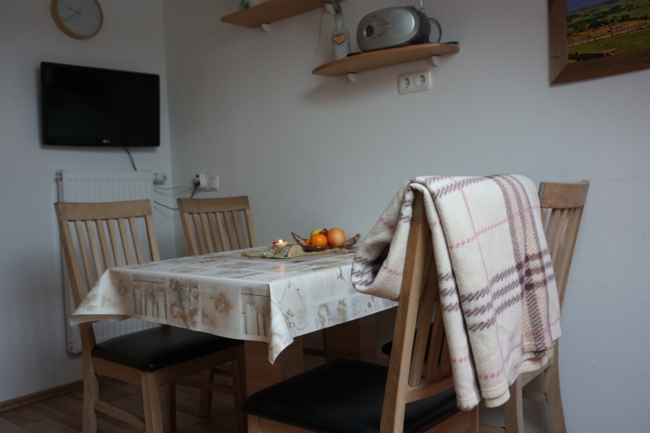 Wohnküche mit Fernseher und 4 Stühlen