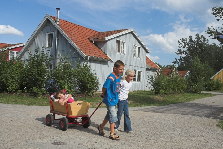 Kinder im Feriendorf, im Hintergrund Haustyp 