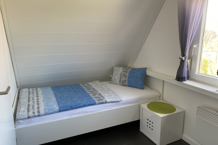 kleines Schlafzimmer mit einem Einzelbett und Sessel 