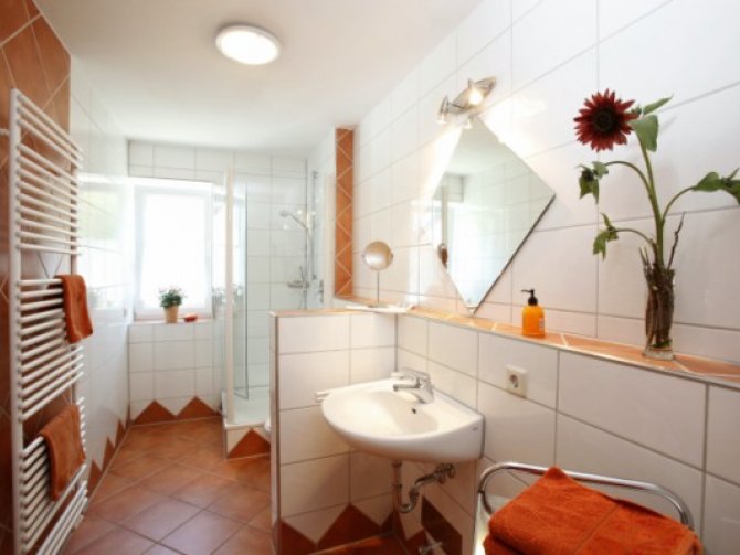 Modernes Badezimmer mit Echtglaskabine, Handtuchtrockner und Fußbodenheizung - hier macht die tägliche Körperpflege Spaß