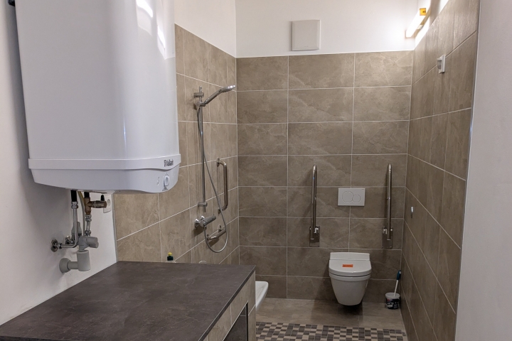 Bad mit WC und Dusche. Barrierefrei, rollstuhlgerechte Abstandsflächen, Stützklappgriffe, unterfahrbarer Waschtisch.