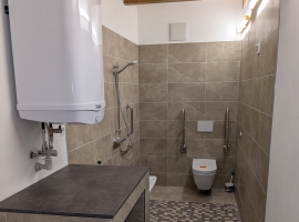 Bad mit WC und Dusche. Barrierefrei, rollstuhlgerechte Abstandsflächen, Stützklappgriffe, unterfahrbarer Waschtisch. 