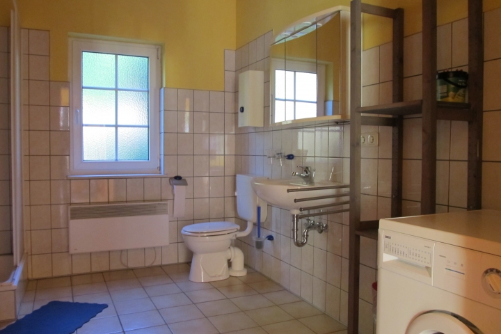 Badezimmer mit Dusche, Wanne und Waschmaschine