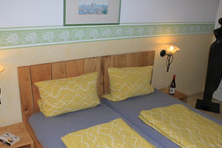 Schlafzimmer mit Doppelbett im Obergeschoss und Kinderreisebett