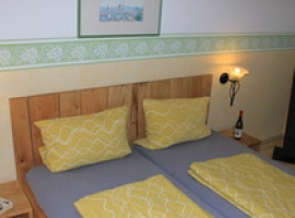Schlafzimmer mit Doppelbett im Obergeschoss und Kinderreisebett
