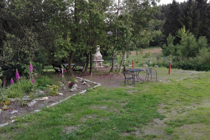 Garten mit Außensteingrill und Gartenmöbeln.