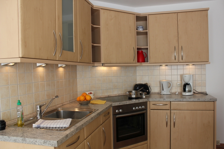 Küche mit Geschirrspüler, Mikrowelle, Herd mit Ceranfeld und Backofen, Kaffeemaschine, Wasserkocher, Toaster