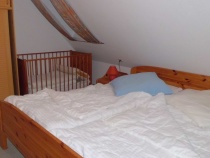 1.  Schlafzimmer mit Doppel - und Kinderreisebett ( nicht aus Holz ) , Kleiderschrank und Rollade an dem Wandfenster, Rollo am Dachfenster zum verdunk