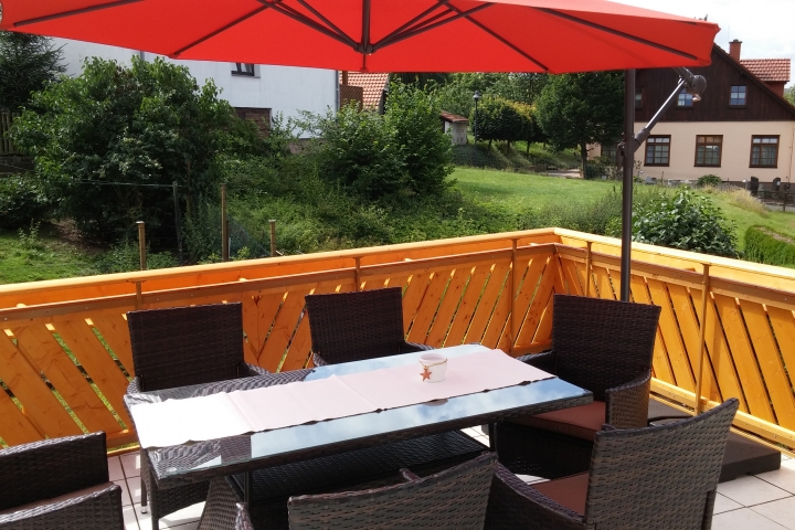 Terrasse mit Bestuhlung und Sonnenschirm