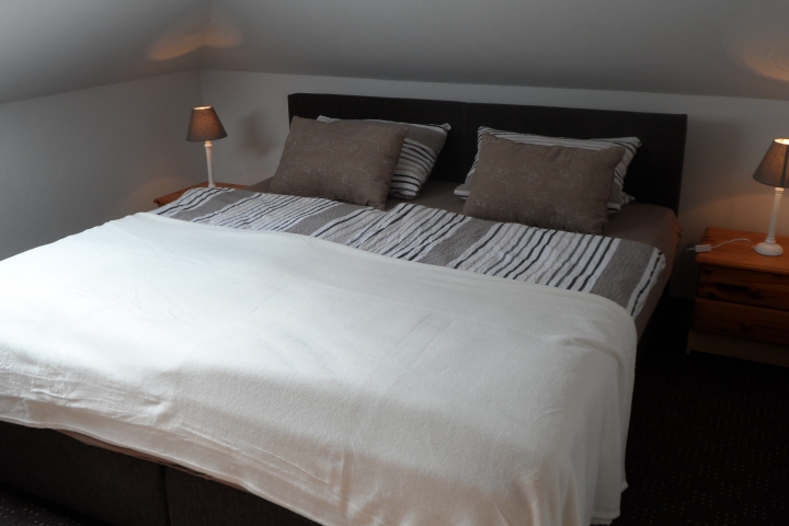 Das Elternschlafzimmer mit einem gemütlichen Boxspringbett.