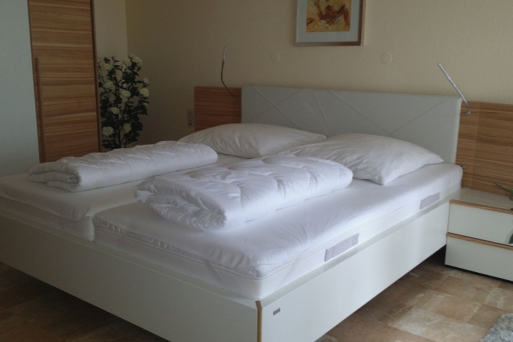 Schlafzimmer mit Doppelbett und Zugang zum Balkon