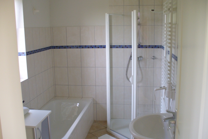 Badezimmer im EG mit Dusche, Badewanne, WC, Fußbodenerwärmung, Handtuchtrockner und Föhn 