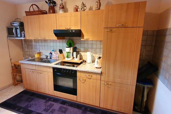 Küchenwand mit Einbauherd, Ceranfeld und Kühlschrank sowie Mikrowelle