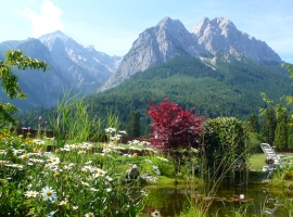 Idyllischer Garten mit Liegewiese am Teich und freiem Bergblick