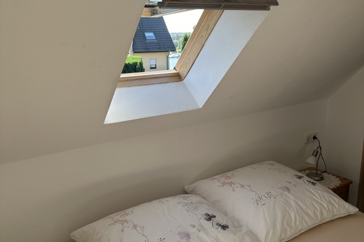 Schlafkammer mit Blick zum Malchower See mit Sportboothafen. In der großen Aufnahme sieht man über dem Fenster einen Hitzeschutz, zusätzlich zur Ve