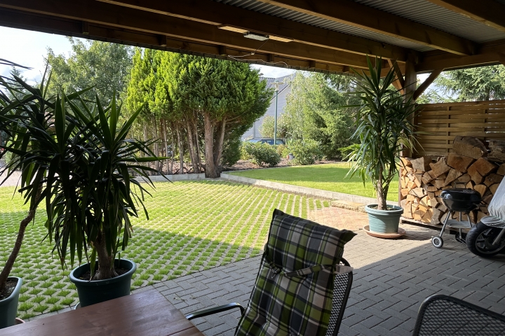 Blick vom für die Wohnung B (Natur) reservierten terrassenartigen Bereich unter dem Carport Richtung Straße.