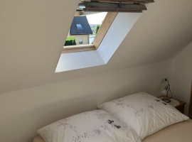 Schlafkammer mit Blick zum Malchower See mit Sportboothafen. In der großen Aufnahme sieht man über dem Fenster einen Hitzeschutz, zusätzlich zur Ve