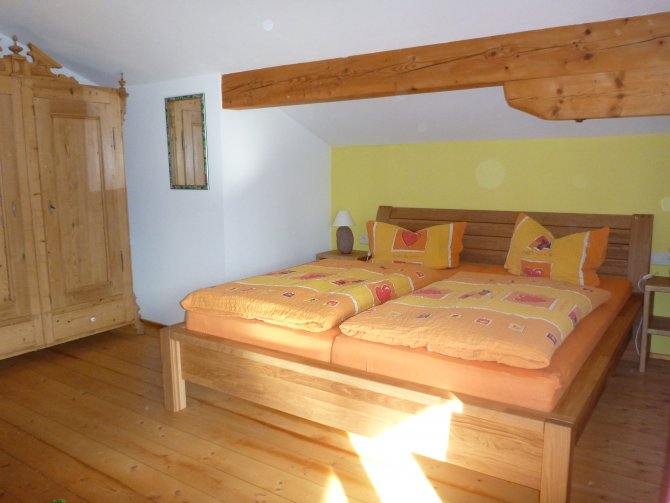 Schlafzimmer mit Vollholz-Doppelbett für angenehmen Schlaf, gemütlichem Sofa mit Kabel-TV und Südbalkon