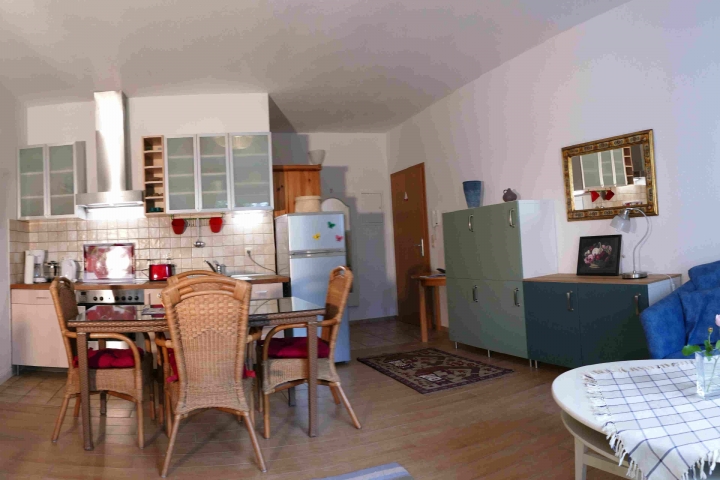 Ferienwohnungen im Gutshaus Neuhof | Großes Wohnzimmer mit Küchenzeile, Ausgang zu Terrasse und Garten.

