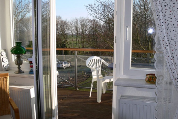 Wohnzimmer mit Ausgang zum Balkon und Sicht auf den großen Garten.