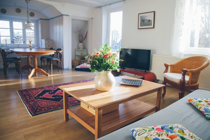 Ferienwohnungen im Gutshaus Neuhof | Wohnzimmer mit Tür zum großen Balkon.