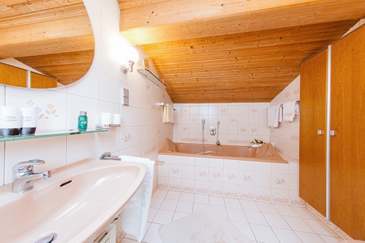Badezimmer mit Badewanne und Dusche mit Sitzgelegenheit