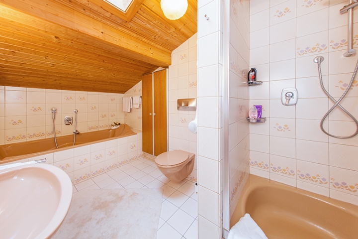 Badezimmer mit Badewanne und Dusche mit Sitzgelegenheit
