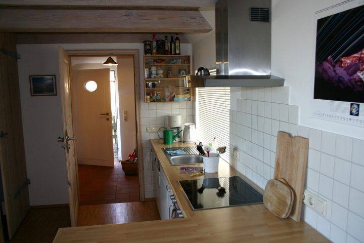 Küchenzeile mit Blick in den Windfang, in dem der Kühl-Gefrierschrank steht