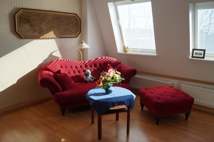 Stadtflitzerbude Ferienwohnungen | Rotes Sofa im Wohnzimmer