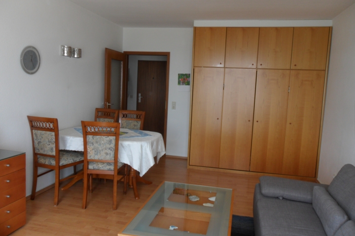 Wohnzimmer mit Rundecke, Esstisch und Schrankklappbetten