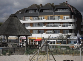 Hier haben Sie den Strand, den Pavillon an der Promenade und die Spielgeräte am Strand im Blick