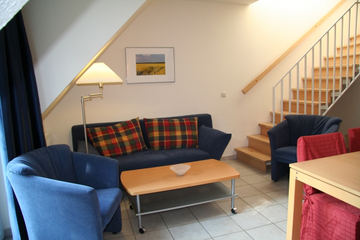 Sitzgruppe im Wohnzimmer mit Treppe zum Schlafzimmer - B