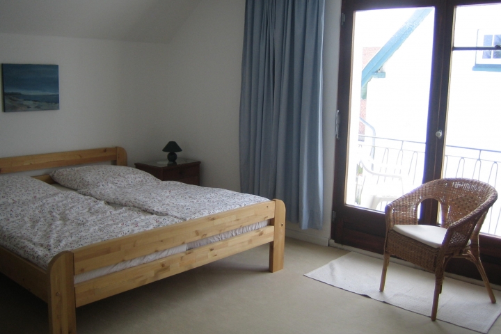 Schlafzimmer 1 mit Balkon und Blick auf den Garten,
Kindergitterbett
