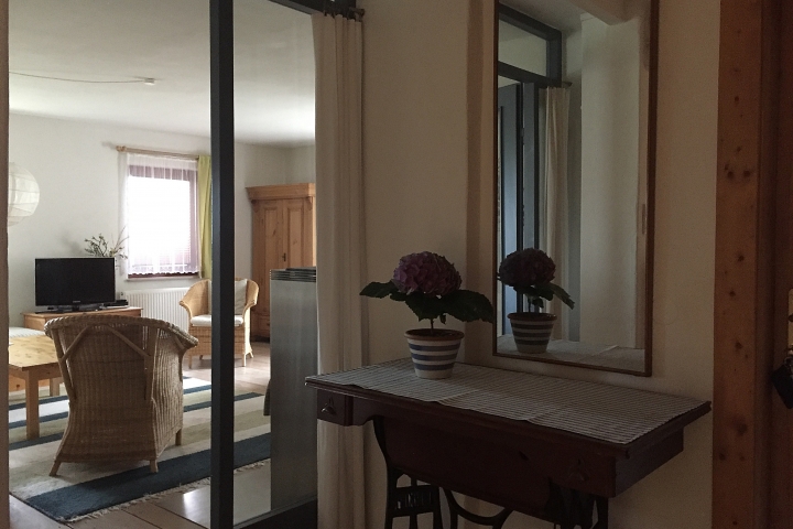 Blick von der Küche zum Wohnzimmer.
Sollte auch das Wohnzimmer zum Schlafen genutzt werden schirmt ein Vorhang die große Glastür ab.