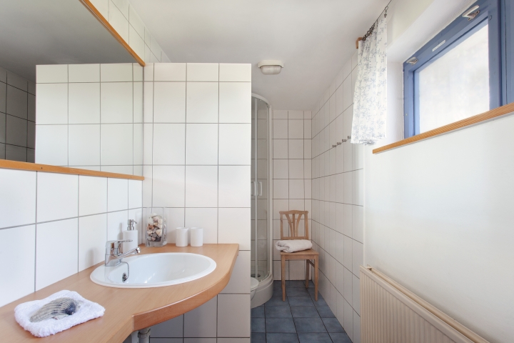 Das Bad verfügt über Fußbodenheizung, Dusche, WC, Fön, und genügend Haken zum Aufhängen